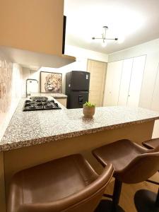a kitchen with a stove and a counter with stools at Brand New Apartment in Lima +10 photos
