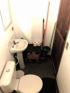 a small bathroom with a toilet and a sink at Beco do Curupira Bangalô in São Luiz do Paraitinga
