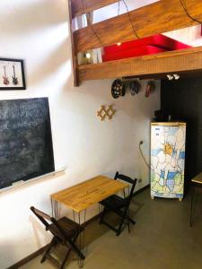 a table and chairs in a room with a chalkboard at Beco do Curupira Bangalô in São Luiz do Paraitinga
