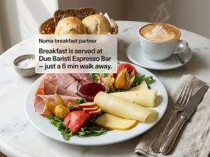 a plate of food on a table with a cup of coffee at Base Apartments in Hamburg
