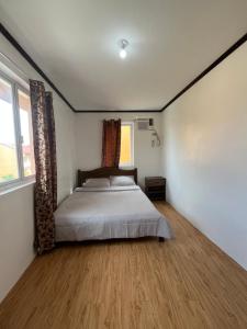 een slaapkamer met een bed en een groot raam bij Jorich home stay in Dumaguete