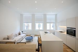 a white living room with a couch and a table at Toison d'Or House 4 in Brussels
