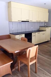 a kitchen with a wooden table and white cabinets at Apartment Schwändelifluh by Interhome in Flühli