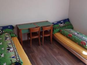 a room with two beds and a desk and a table at Apartment Schwändelifluh by Interhome in Flühli