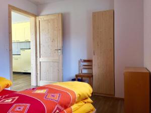 a bedroom with a bed and a chair and a door at Apartment Schwändelifluh by Interhome in Flühli