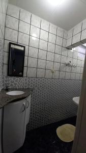 een badkamer met 2 wastafels en een betegelde muur bij Pousada Mamulengo in Porto De Galinhas