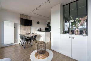 - une cuisine et une salle à manger avec des placards blancs et une table dans l'établissement La Résidence Le Belvédère - Avec Balcon, à Le Tholy