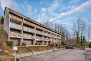 un bâtiment avec un parking devant dans l'établissement La Résidence Le Belvédère - Avec Balcon, à Le Tholy
