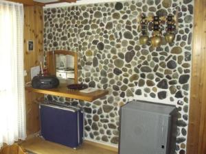 a room with a stone wall with a mirror and a television at Apartment Bijou by Interhome in Alt Sankt Johann
