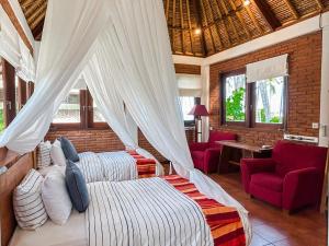 a bedroom with a bed with a mosquito net at Villa Anjani - Ocean view Villa, With Private Garden and Cook - Candidasa in Candidasa