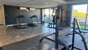 a gym with several tread machines in a room at Loft Central com garagem in Pelotas