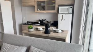 a small kitchen with a counter and a refrigerator at Loft Central com garagem in Pelotas