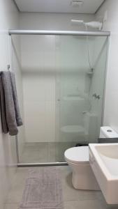 a bathroom with a shower and a toilet and a sink at Loft Central com garagem in Pelotas +5 photos