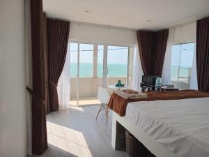 a bedroom with a bed and a view of the ocean at Inuli Coco Hut in Kalutara