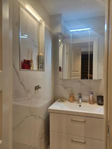 a white bathroom with a sink and a mirror at Malmoxie Unic Garden House in Oxie +22 photos