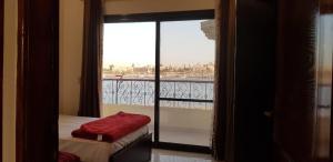 a room with a balcony with a bed and a window at El BOB HOUSE in Luxor +10 photos