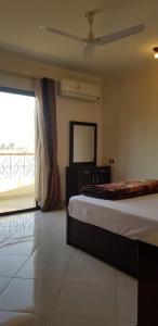 a bedroom with a bed and a window and a mirror at El BOB HOUSE in Luxor