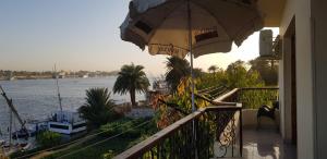 a balcony with an umbrella and a view of the water at El BOB HOUSE in Luxor