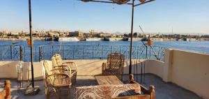 a patio with chairs and tables and a view of the water at El BOB HOUSE in Luxor