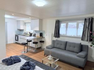 uma sala de estar com um sofá e uma cozinha em Secret Paradise em Attalens