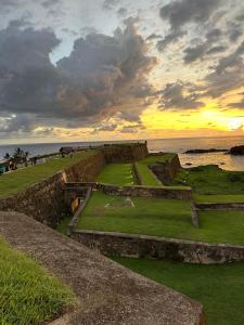 a view of the ruins of a building near the ocean at The Regent Villa in Unawatuna