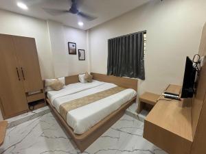 a bedroom with a bed and a television in it at Hotel meghshyam in Sānand