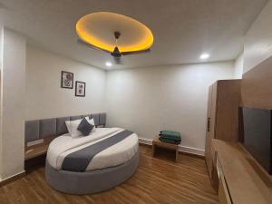 a bedroom with a bed with a yellow ceiling at Hotel meghshyam in Sānand