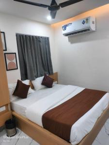 a bedroom with a large bed with avertisementatronatronstrationstrationstration at Hotel meghshyam in Sānand