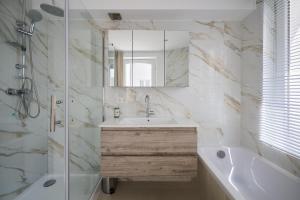 a bathroom with a sink and a tub and a mirror at Toison d'Or & saunna 2 in Brussels +52 photos