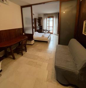 een woonkamer met een bank en een bed bij Rustic Apartment in Bergamo