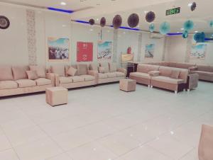 een woonkamer met banken en tafels in een kamer bij فندق الواحة الماسية 2 in Quai