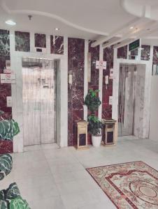 een lobby met twee deuren en een tapijt bij فندق الواحة الماسية 2 in Quai