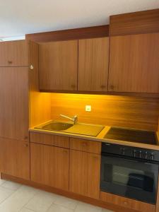 een keuken met houten kasten en een spoelbak bij Cozy Studio with Wellness in Goms in Blitzingen