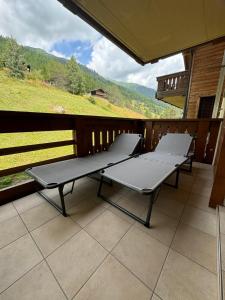 twee banken op een balkon met uitzicht op een berg bij Cozy Studio with Wellness in Goms in Blitzingen
