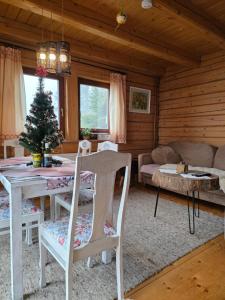 een woonkamer met een tafel en een kerstboom bij Apartamenty SPOKOLOKO Letniczówka Widoki in Bystra