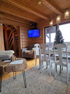 een woonkamer met een tafel en stoelen en een kerstboom bij Apartamenty SPOKOLOKO Letniczówka Widoki in Bystra
