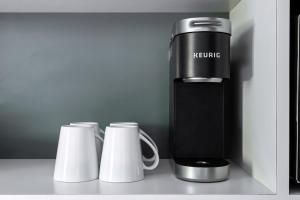 a coffee maker and two cups on a counter at Kasa Edison House South End Dilworth Charlotte in Charlotte