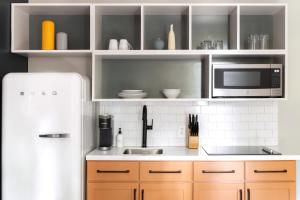 a kitchen with a white refrigerator and a microwave at Kasa Edison House South End Dilworth Charlotte in Charlotte