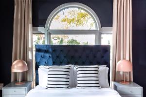 a bed with a blue headboard in front of a window at Kasa Edison House South End Dilworth Charlotte in Charlotte