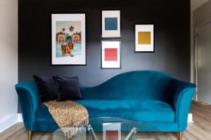 a blue couch in a living room with pictures on the wall at Kasa Edison House South End Dilworth Charlotte in Charlotte