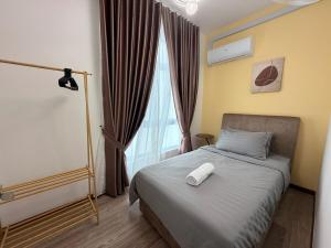 a bedroom with a bed with a white object on it at Self Check in at Classy 3BR Kajang in Kajang +33 photos