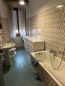 een badkamer met een bad, een toilet en een wastafel bij Rustic Apartment in Bergamo