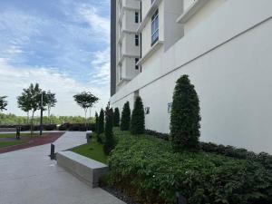 a building with bushes and trees next to a building at Self Check in at Classy 3BR Kajang in Kajang