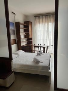 een slaapkamer met een wit bed en een raam bij Rustic Apartment in Bergamo