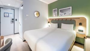 een slaapkamer met een wit bed en een groene muur bij Campanile PRIME - Lyon Centre - Gare Perrache in Lyon