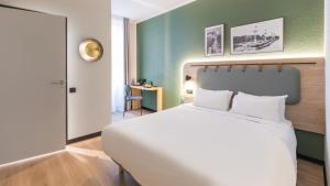 een slaapkamer met een wit bed en een groene muur bij Campanile PRIME - Lyon Centre - Gare Perrache in Lyon