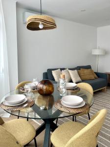 a living room with a glass table and chairs at JC Apartments in Amadora