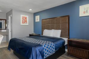 una camera da letto con un letto con una parete blu di Golden Inn Dallas by Hotel O a Dallas