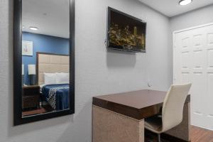 specchio in camera con letto e scrivania di Golden Inn Dallas by Hotel O a Dallas