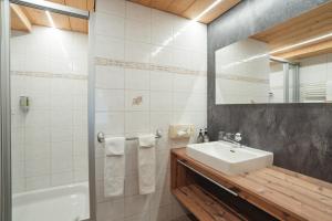 a bathroom with a sink and a mirror and a tub at Hotel Matterhornblick in Zermatt +119 photos
